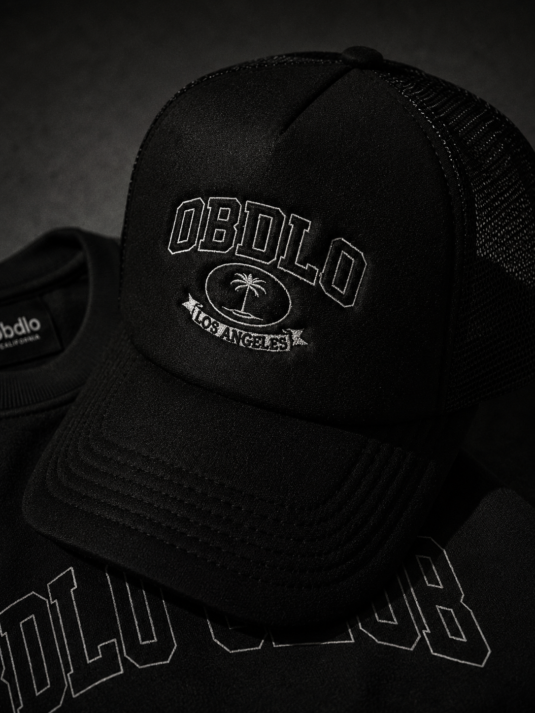 Black cap with 'OBDLO' logo on a dark background
